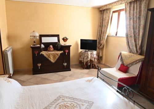 a bedroom with a bed and a tv and a chair at casa di nunzia in Caiazzo
