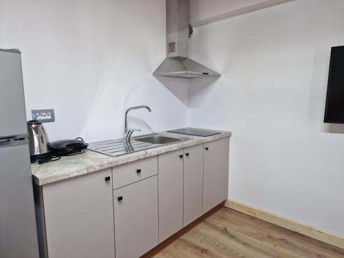 a white kitchen with a sink and a stove at Sea's Villa in Ksamil