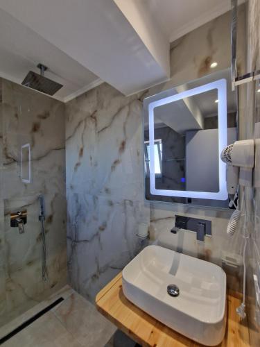 a bathroom with a sink and a mirror at Sea's Villa in Ksamil