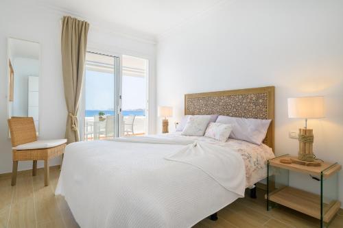 ein weißes Schlafzimmer mit einem großen Bett und einem Fenster in der Unterkunft La Vida Oceana in Costa Teguise