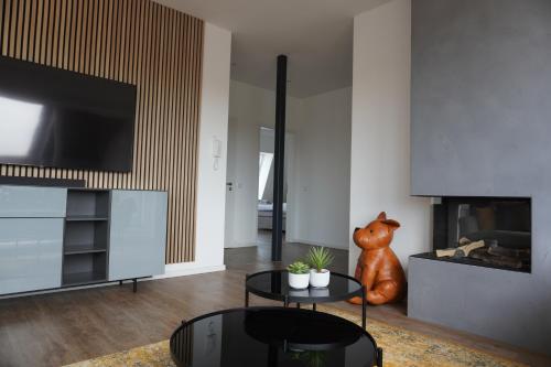 a living room with a tv and a table at Sleepwell Apartment - Ehrensteinsuite in Leipzig