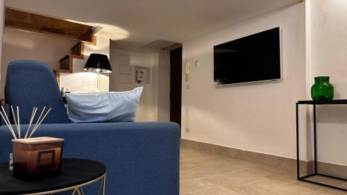 a living room with a blue couch and a tv at Murat48 in Bari