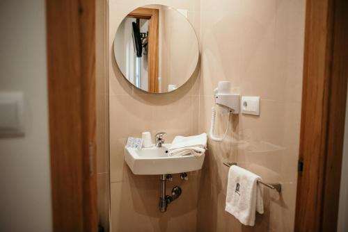 a bathroom with a sink and a mirror at PENSIÓN BERENGUELA in Melide