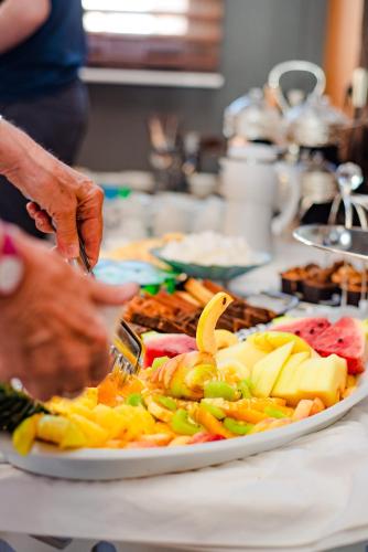 a person preparing a plate of food on a table at Hotel Vents Des Iles in Essaouira