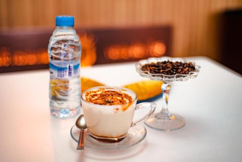 a table with a cup of coffee and a bottle of water at Hotel Vents Des Iles in Essaouira
