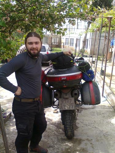 a man is standing next to a motorcycle at Giorgi's Homestay in Kutaisi