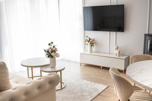 sala de estar con TV, mesa y sillas en Domki na wyłączność - Apartamenty Koziniec 5, Myczkowce, Solina, Bieszczady, en Bereżnica Niżna