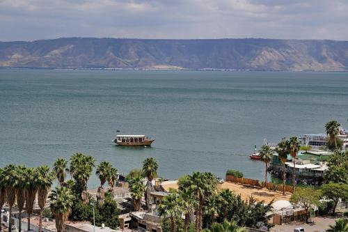 ein großes Boot im Wasser mit Palmen in der Unterkunft Levication 3 bedroom lakefront in Tiberias