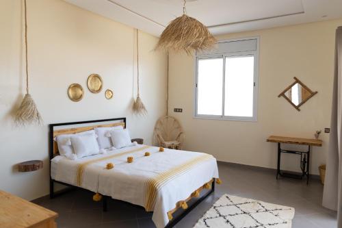 a bedroom with a large bed and a window at Wavy Days in Tamraght Ouzdar