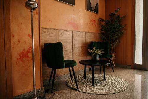 2 sillas verdes y una mesa en una habitación en PENSIÓN BERENGUELA, en Melide