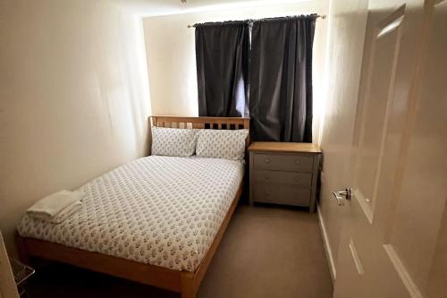 a small bedroom with a bed and a window at Sianavi Apartments in Kettering