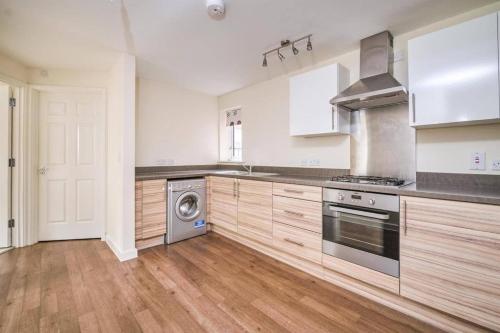 a kitchen with a stove and a washing machine at Sianavi Apartments in Kettering