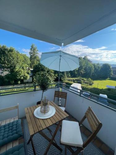 a balcony with a table and chairs and an umbrella at Apartment im Herzen von Sonthofen in Sonthofen