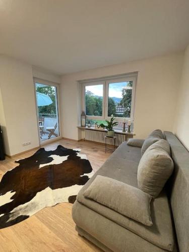 a living room with a couch and a cow rug at Apartment im Herzen von Sonthofen in Sonthofen