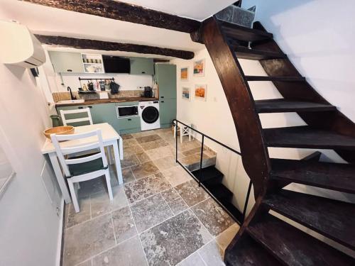 a small kitchen with a spiral staircase in a room at Triplex de Saint-Paul Free public parking in Saint-Paul-de-Vence