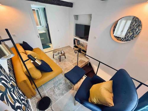 ein Wohnzimmer mit einem gelben Sofa und einem Spiegel in der Unterkunft Triplex de Saint-Paul Free public parking in Saint-Paul-de-Vence