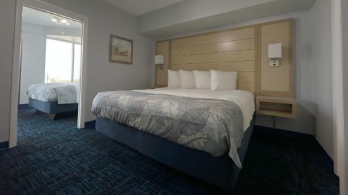 a hotel room with a large bed and a window at Ocean East Resort Club in Ormond Beach