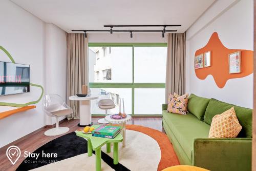 uma sala de estar com um sofá verde e uma mesa em Stayhere Casablanca - CIL - Vibrant Residence em Casablanca