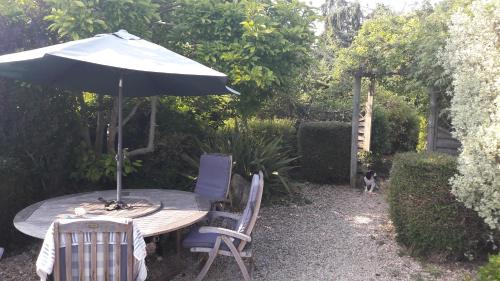 a table and chairs with an umbrella and a dog at Cotswold VIP Regency Lodge in Cheltenham