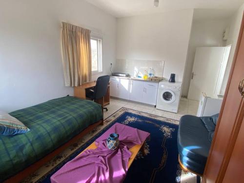 Bayt JālāにあるPrivate 1 bedroom studio in Beit Jala Bethlehemのベッド、テーブル、キッチンが備わる客室です。