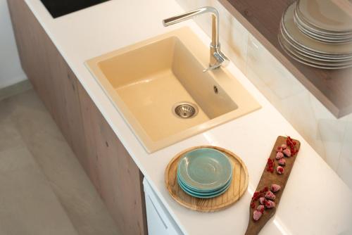 a kitchen counter with a sink and plates on it at CeraMio Suites in Limenas