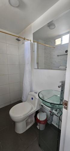 a bathroom with a toilet and a glass sink at Hotel Bayadera Real in Medellín
