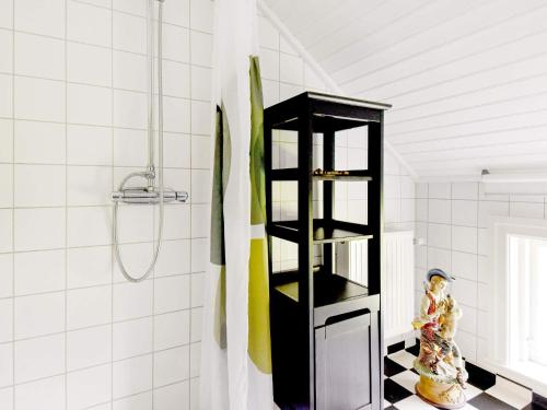 a black shelf in a bathroom with a shower at 12 person holiday home in HOVA in Hova