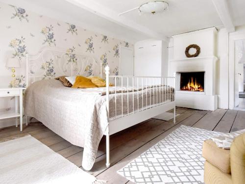 Dormitorio blanco con cama y chimenea en Five-Bedroom Holiday home in Hova 2 en Hova