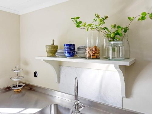 a kitchen with a sink and a shelf with dishes at 12 person holiday home in HOVA in Hova