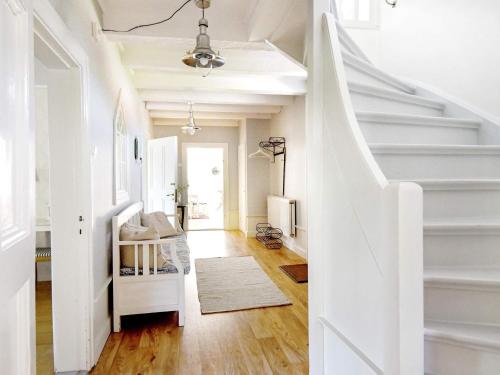 a white staircase in a living room with wood floors at 12 person holiday home in HOVA in Hova