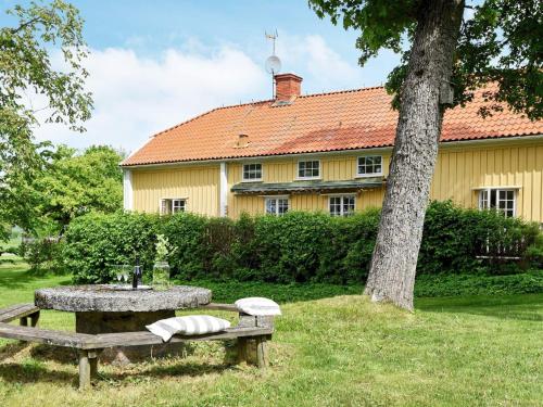 a picnic table and a tree in front of a building at 12 person holiday home in HOVA in Hova