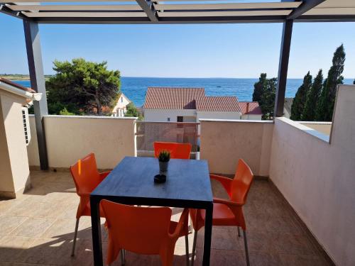 a table and chairs on a balcony with a view of the ocean at Villa Gaj in Novalja