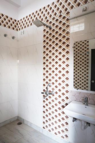 a white bathroom with a sink and a mirror at Aarambh Residency in Khajurāho