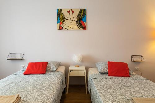a room with two beds and a painting on the wall at Nomad Sud Studios in Town Center in Cahul