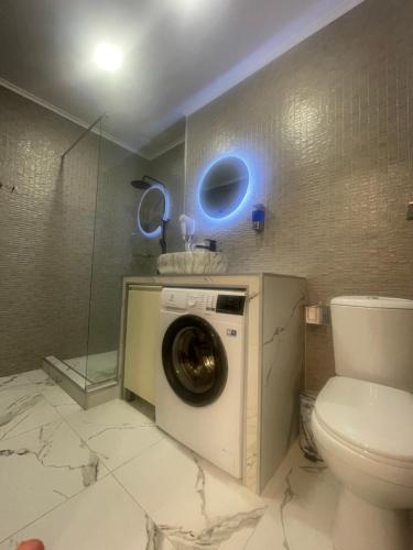 a bathroom with a washing machine and a toilet at Sano's Home in Kutaisi