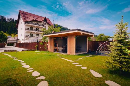 a garden with a pathway leading to a house at Chalet 173 in Gura Humorului
