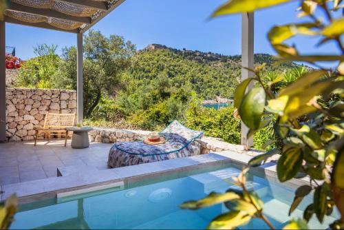 a house with a swimming pool with a view of a mountain at Chromata Assos Villas Kefalonia in Asos