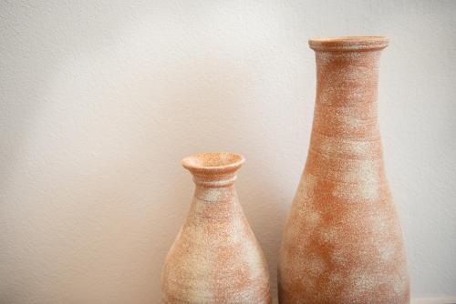 two vases sitting next to each other on a wall at CeraMio Suites in Limenas