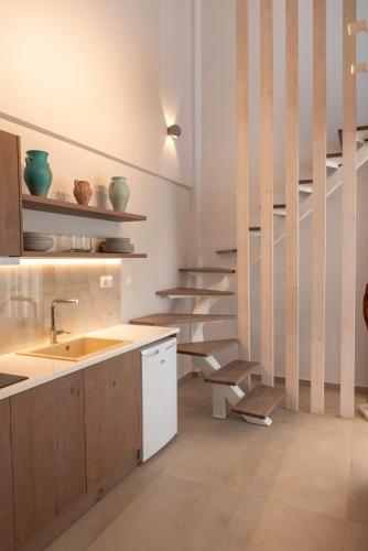 a kitchen with a sink and some stairs at CeraMio Suites in Limenas
