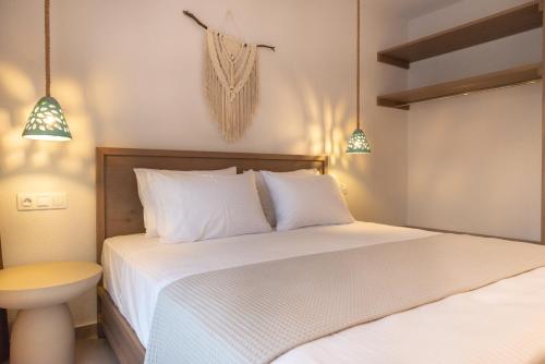 a bedroom with two beds and two pendant lights at CeraMio Suites in Limenas