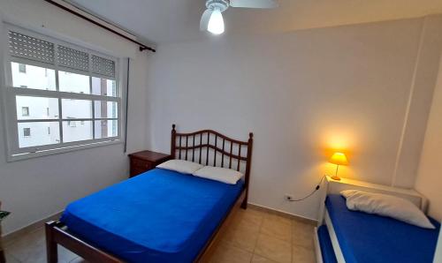 a bedroom with two beds and a window at Ap confortável - Praia de Pitangueiras - Beach Host in Guarujá