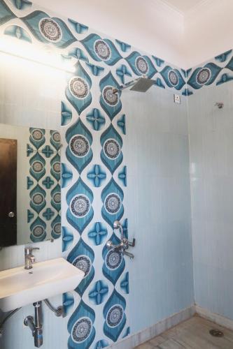a bathroom with blue and white plates on the wall at Aarambh Residency in Khajurāho