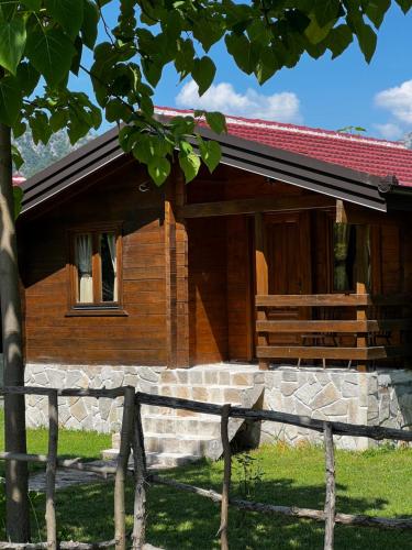 a wooden house with a fence in front of it at Orahovo Cottages in Virpazar