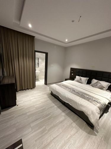 a bedroom with a large bed and a bathroom at Cast Home in Ahad Rafidah