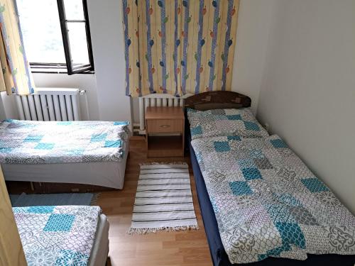 ein kleines Zimmer mit 2 Betten und einem Fenster in der Unterkunft Vila v Modre-Harmónii in Modra