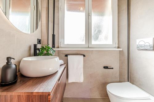a bathroom with a sink and a toilet and a window at Japandi, Appartamento Zona Porto Mediceo Livorno in Livorno