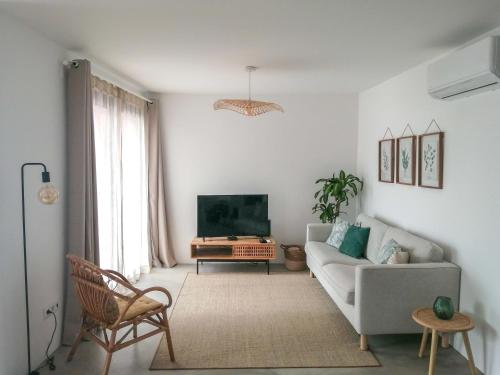 uma sala de estar com um sofá e uma televisão em Terreiro Ocean House - Sea View em São Roque