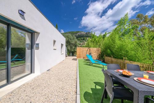 a garden with a table and chairs and a patio at Charmante Maison entre Cannes et Nice in Le Bar-sur-Loup