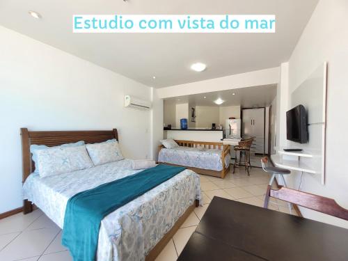 a bedroom with a bed and a dining room at Loft Prainha in Arraial do Cabo