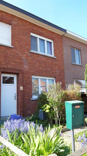 a brick house with a white door and some flowers at Feel at home in Leuven in Leuven